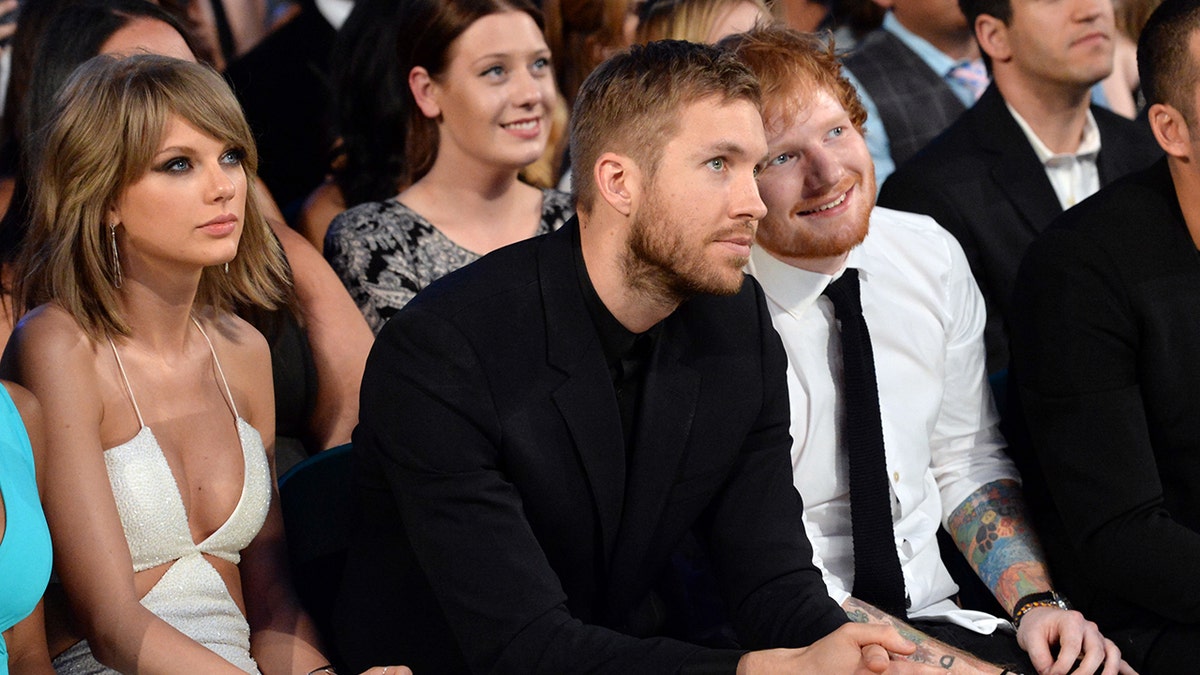 Taylor Swift, Calvin Harris and Ed Sheeran sitting in the audience