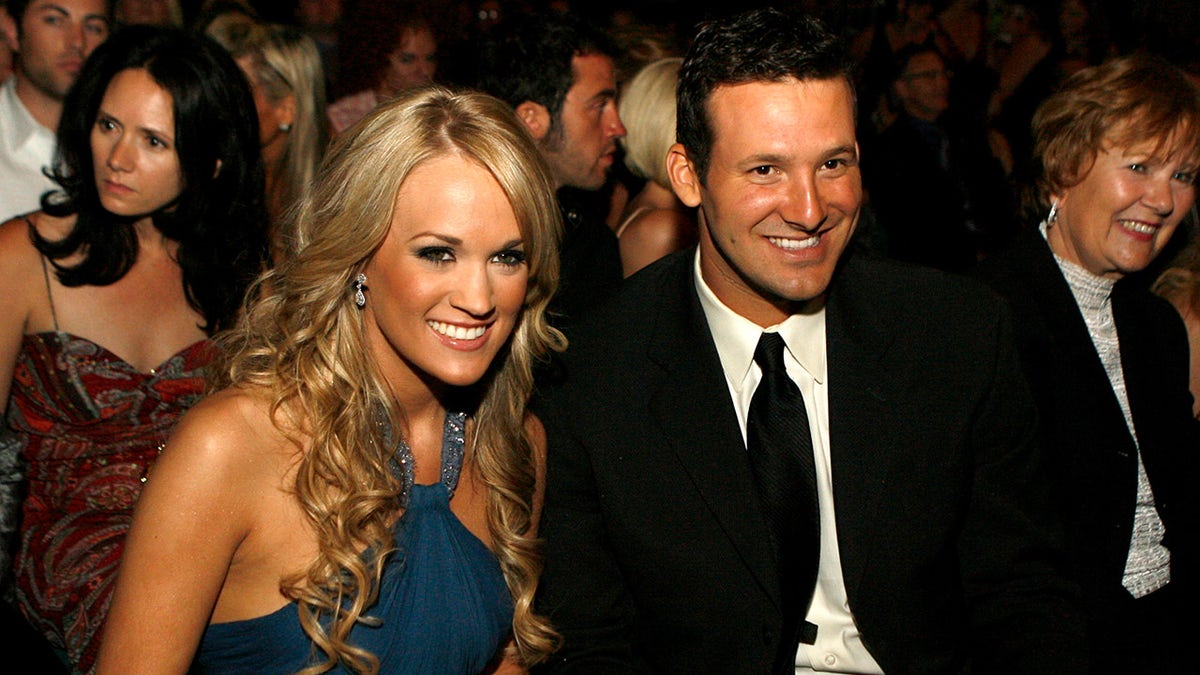 Carrie Underwood sits next to Tony Romo at awards show