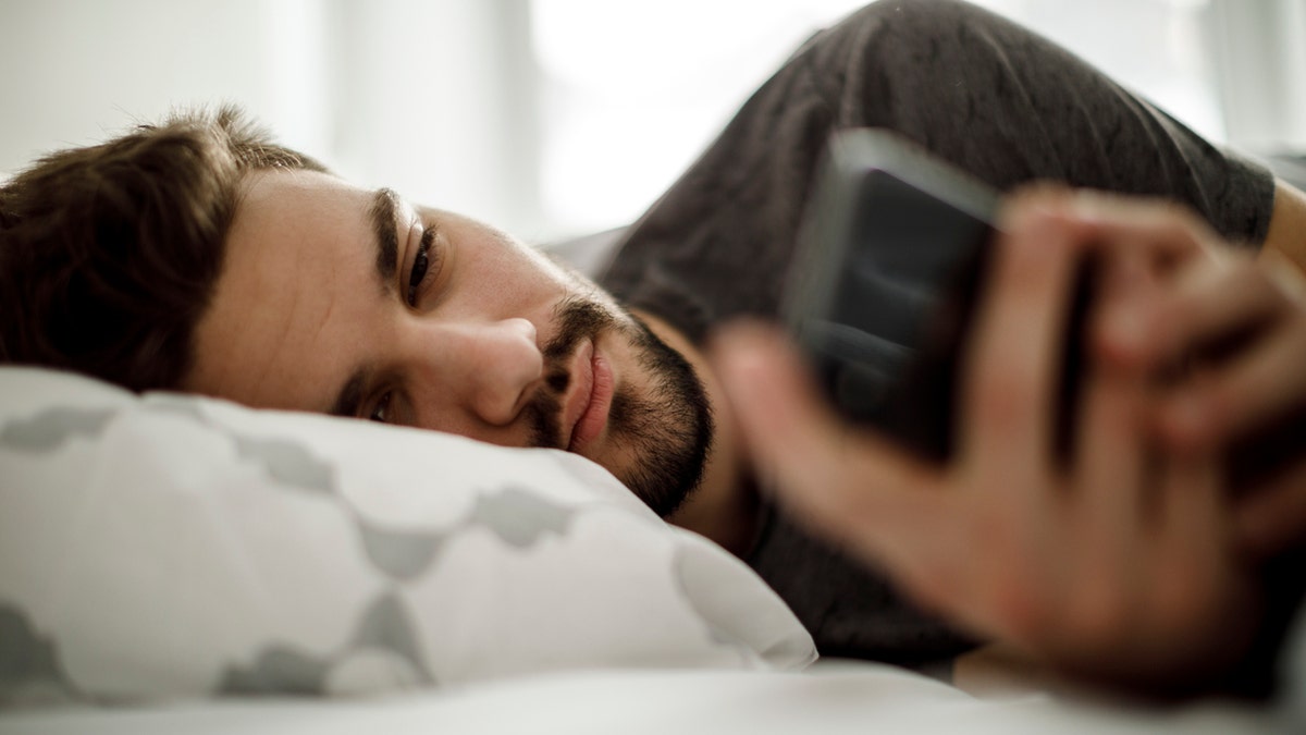 Man on his phone in bed