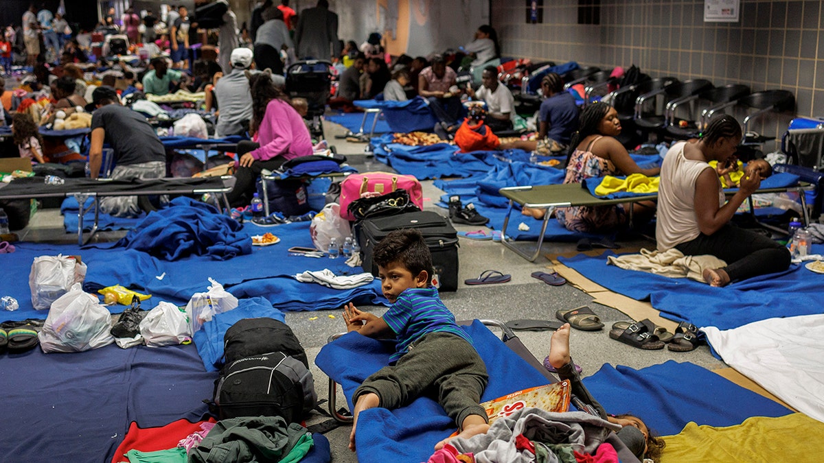 Migrants on the floor and on cots at a makeshift shelter at Chicagos OHare International Airport