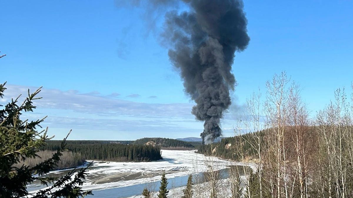 Smoke rises after a Douglas C-54 Skymaster plane crashed into the Tanana River outside Fairbanks, Alaska